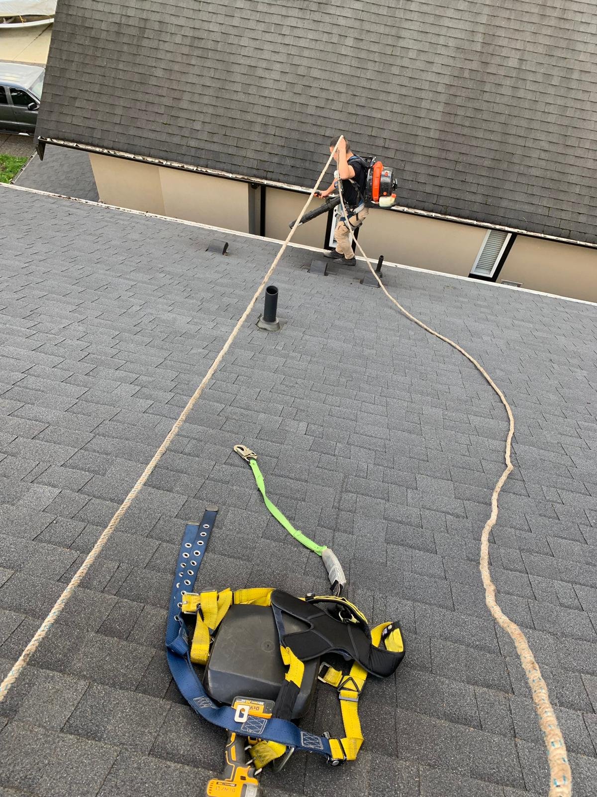 Quick Sidekick technician using a leaf blower to remove debris from a roof in Vancouver