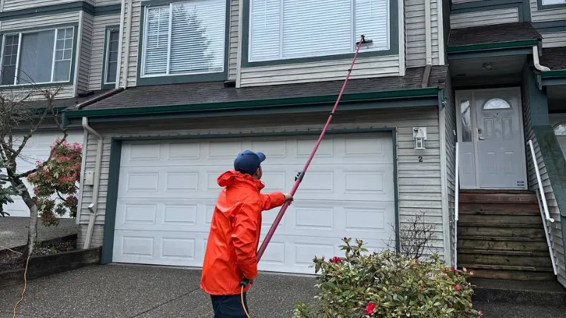 Worker cleaning exterior glass window with squeegee