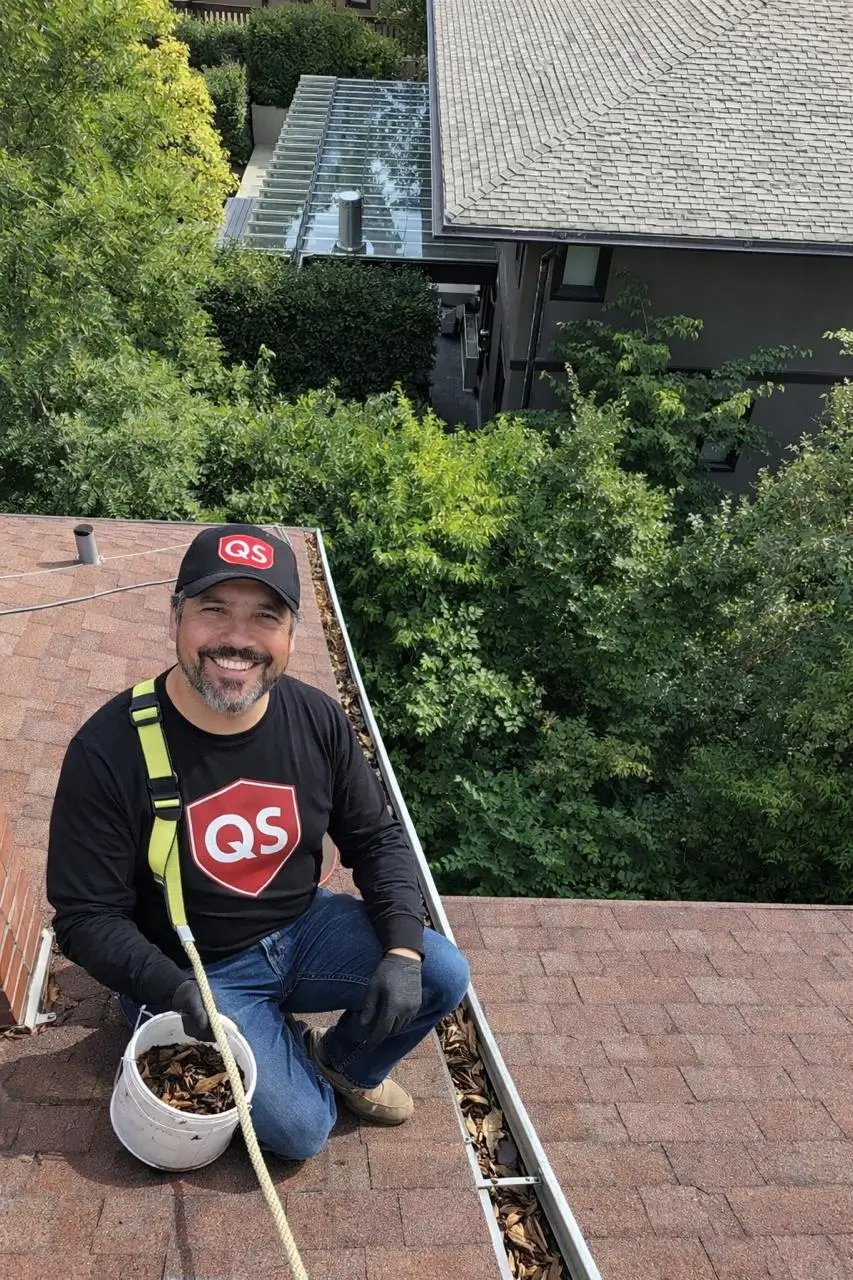 Professional gutter cleaning service in Vancouver by Quick Sidekick removing leaves and debris from residential roof gutters.