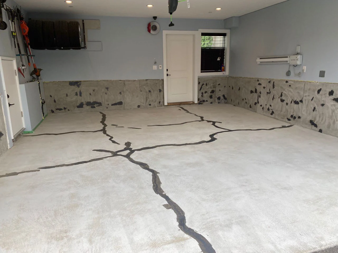 Before epoxy flooring installation in Burnaby showing dull cracked concrete garage floor