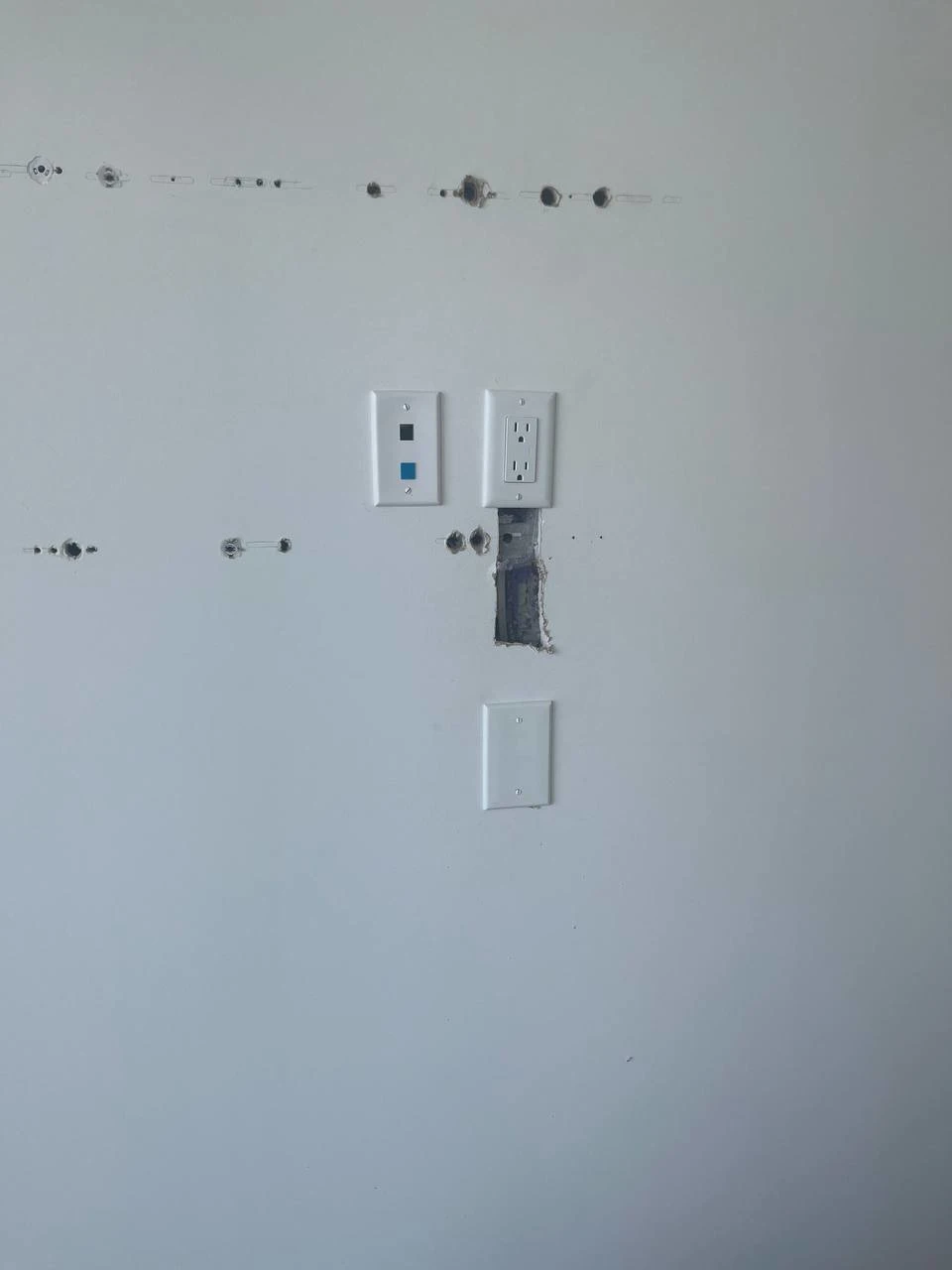 After drywall repair in Burnaby showing professionally patched hole with smooth painted wall finish