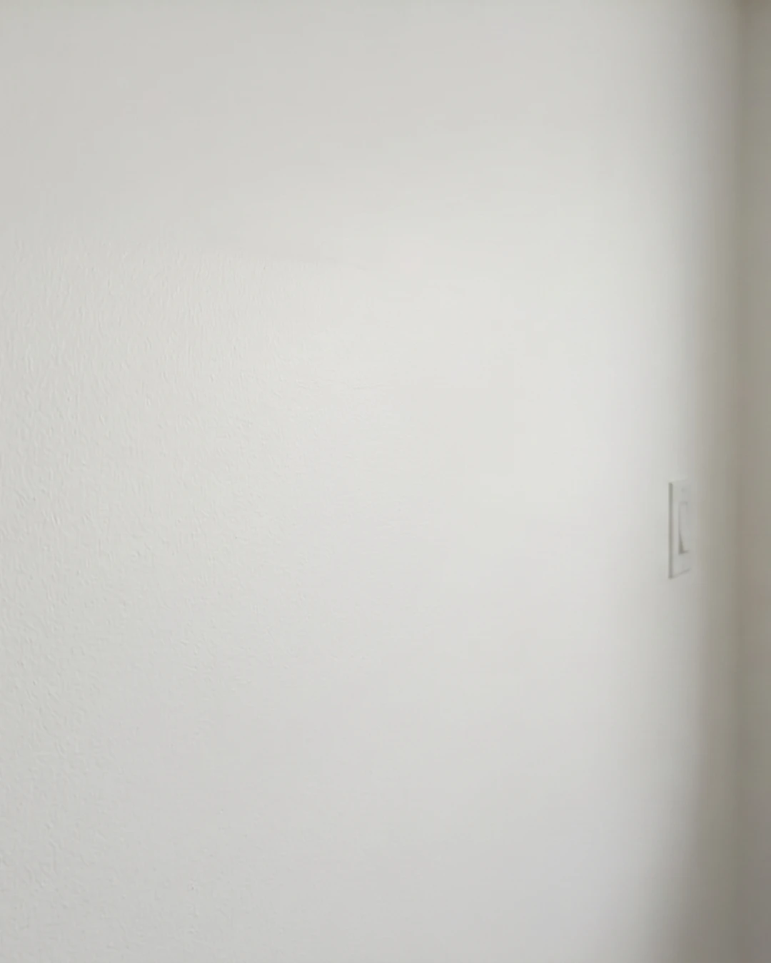 After drywall repair in Burnaby showing rip and tear in wall fully restored with smooth painted surface