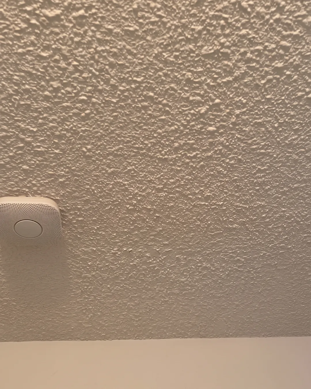 After popcorn ceiling repair in Burnaby showing professionally finished smooth ceiling with seamless drywall repair and clean uniform appearance