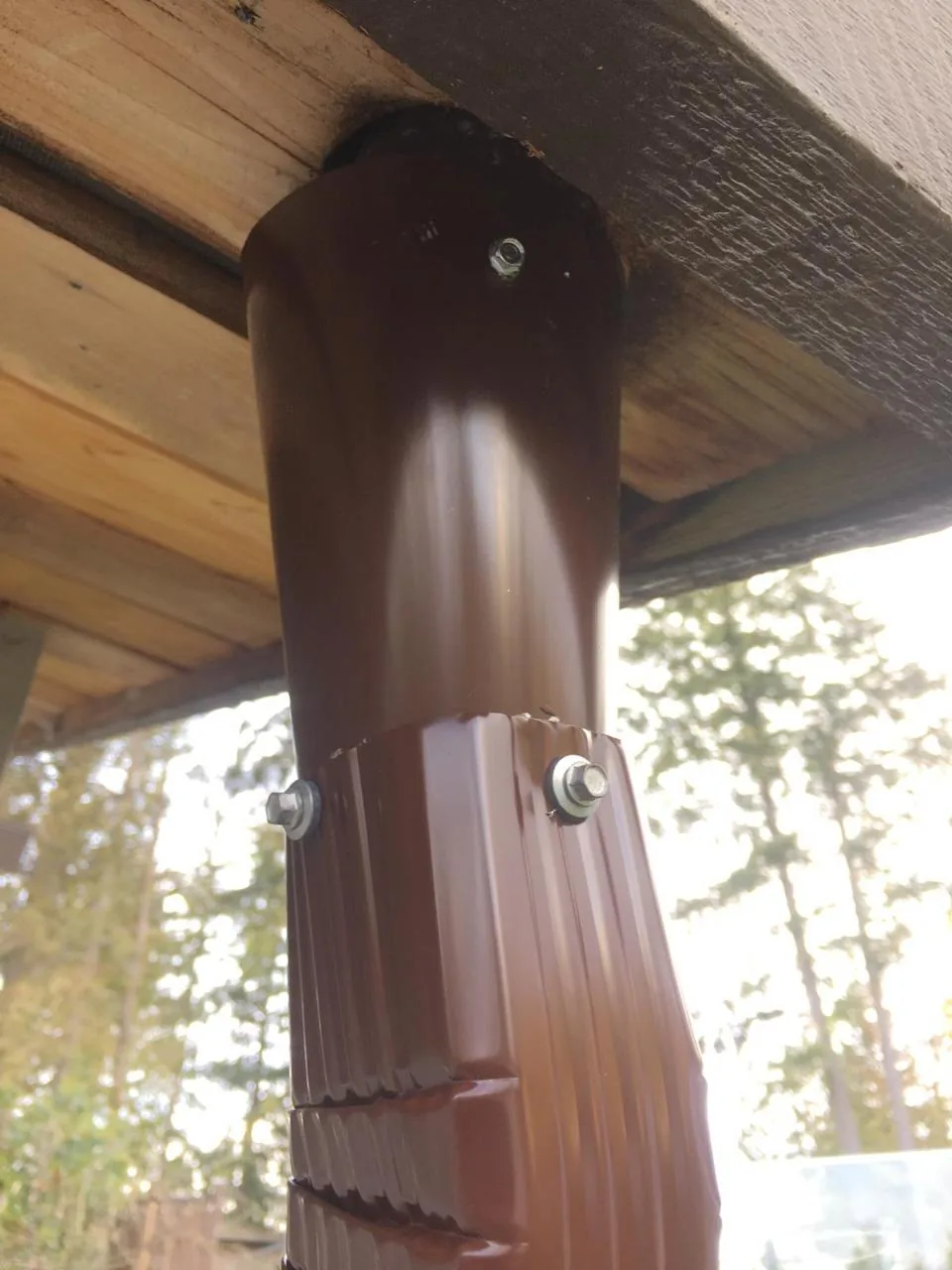 New brown downspout securely installed after professional gutter repair in Vancouver BC