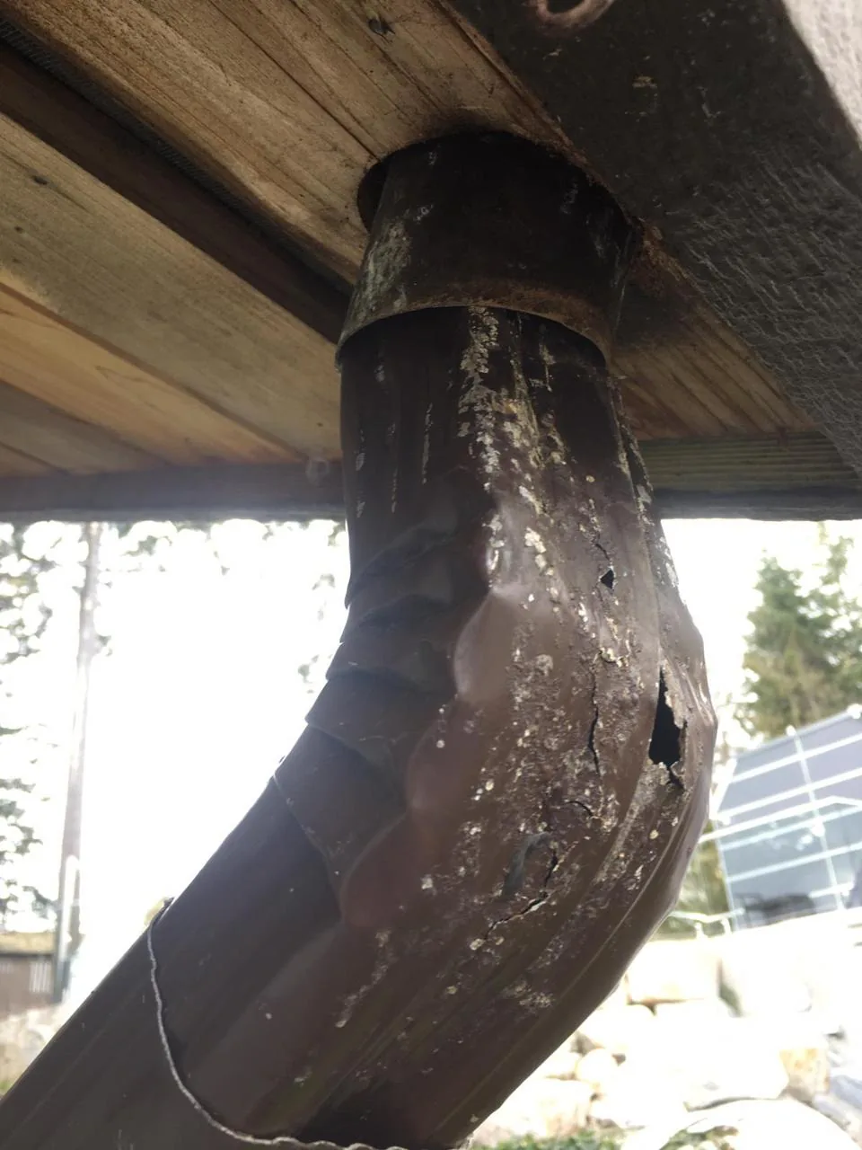 Old cracked and corroded downspout elbow before gutter repair in Vancouver BC