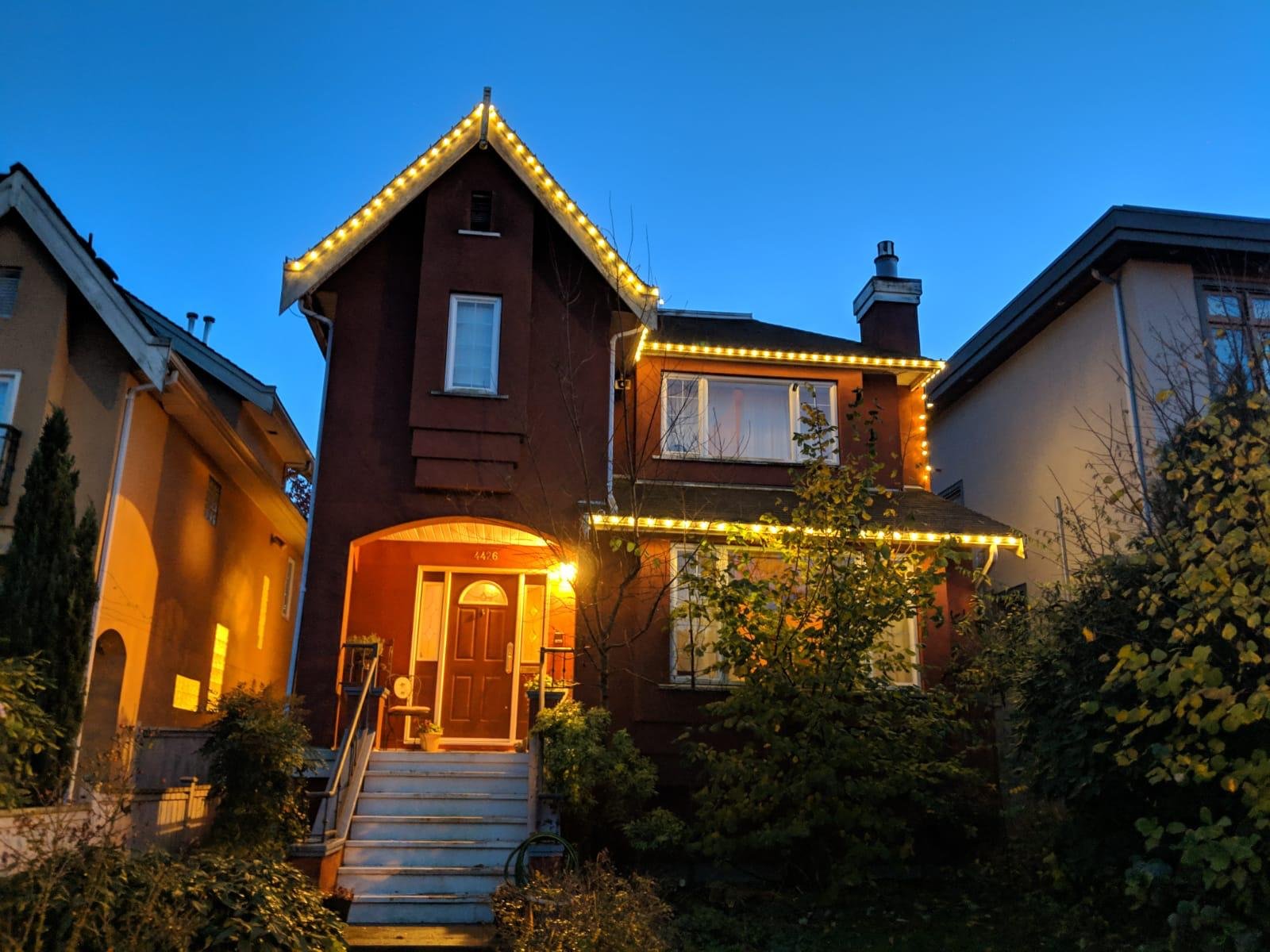 Christmas light installation on a high roof peak