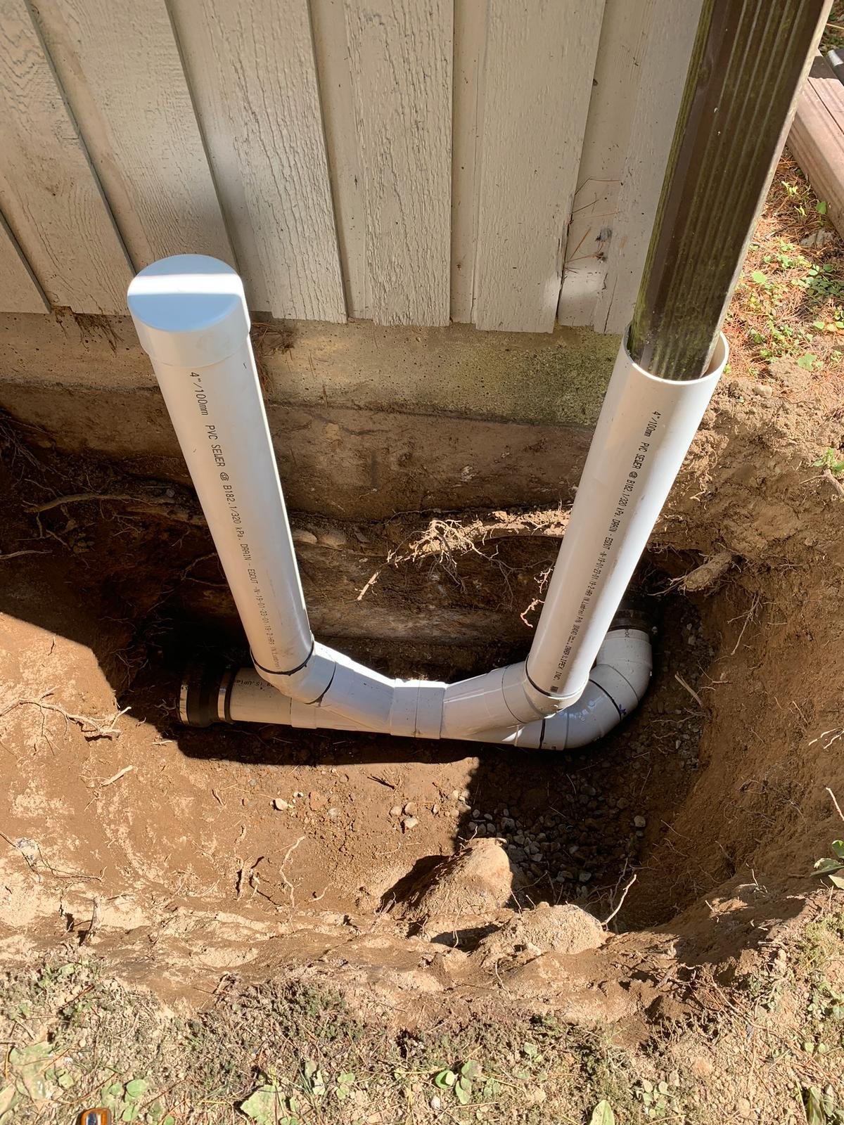 Downspout connected to underground yard drainage in Vancouver