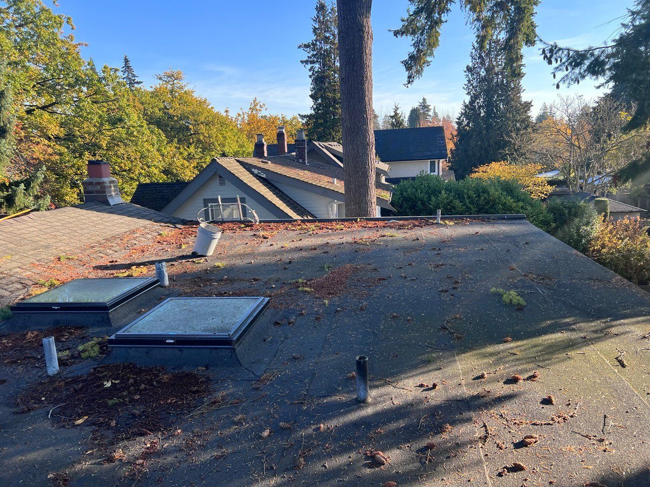 Debris accumulated around rooftop equipment before flat roof cleaning