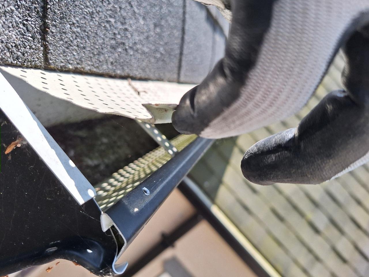 Removing gutter guards to clean the gutters underneath in Vancouver