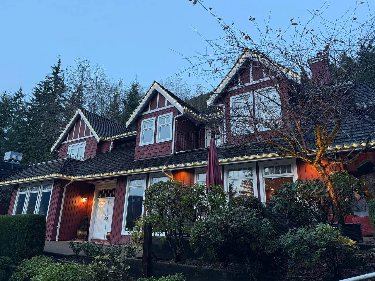 Vancouver house with Christmas lights installed along rooflines and peaks