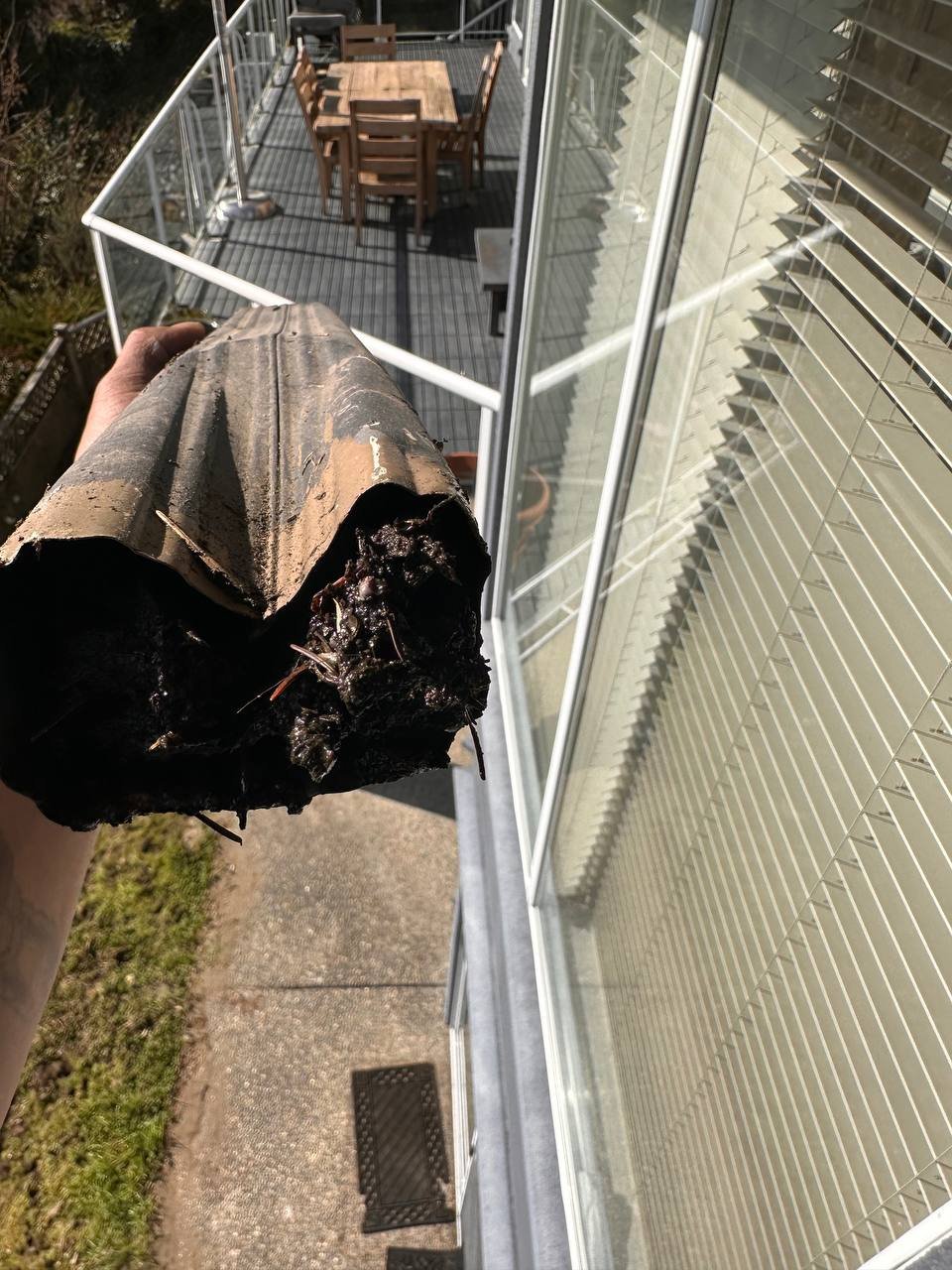 Dented and damaged downspout requiring replacement in Vancouver