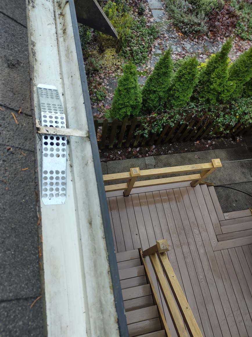Gutter basket protecting a downspout opening from leaves and debris
