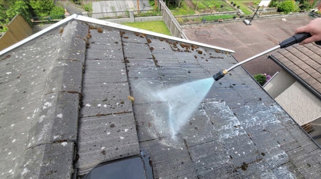 Step one of soft wash roof cleaning applying roof cleaning solution