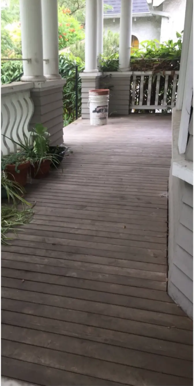 Wooden deck before pressure washing with dark dirt and algae buildup