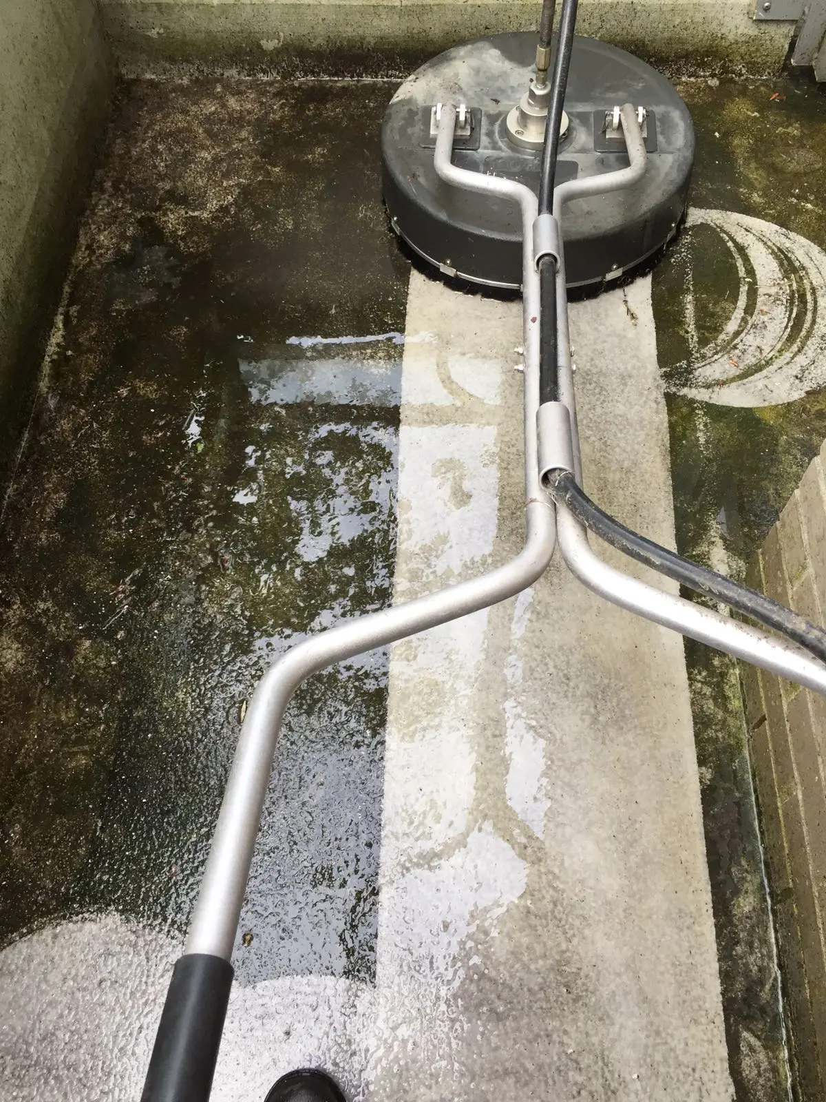 Professional driveway pressure washing with a flat surface cleaner in Vancouver