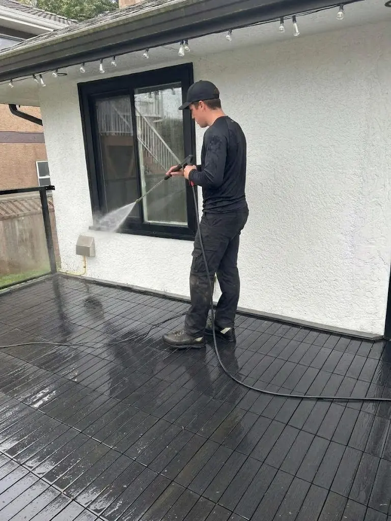 Quick Sidekick technician cleaning a house exterior using soft washing methods